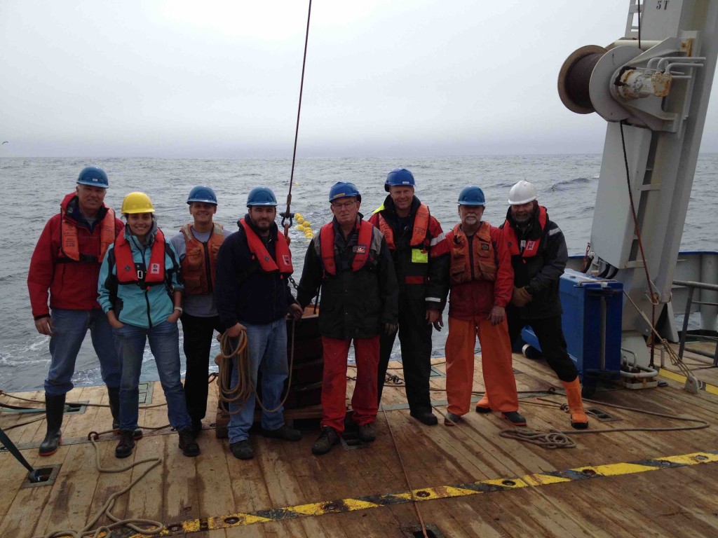 The mooring team with R/V Pelagia deck crew, standing by a mooring anchor while towing the mooring to its final deployment spot.