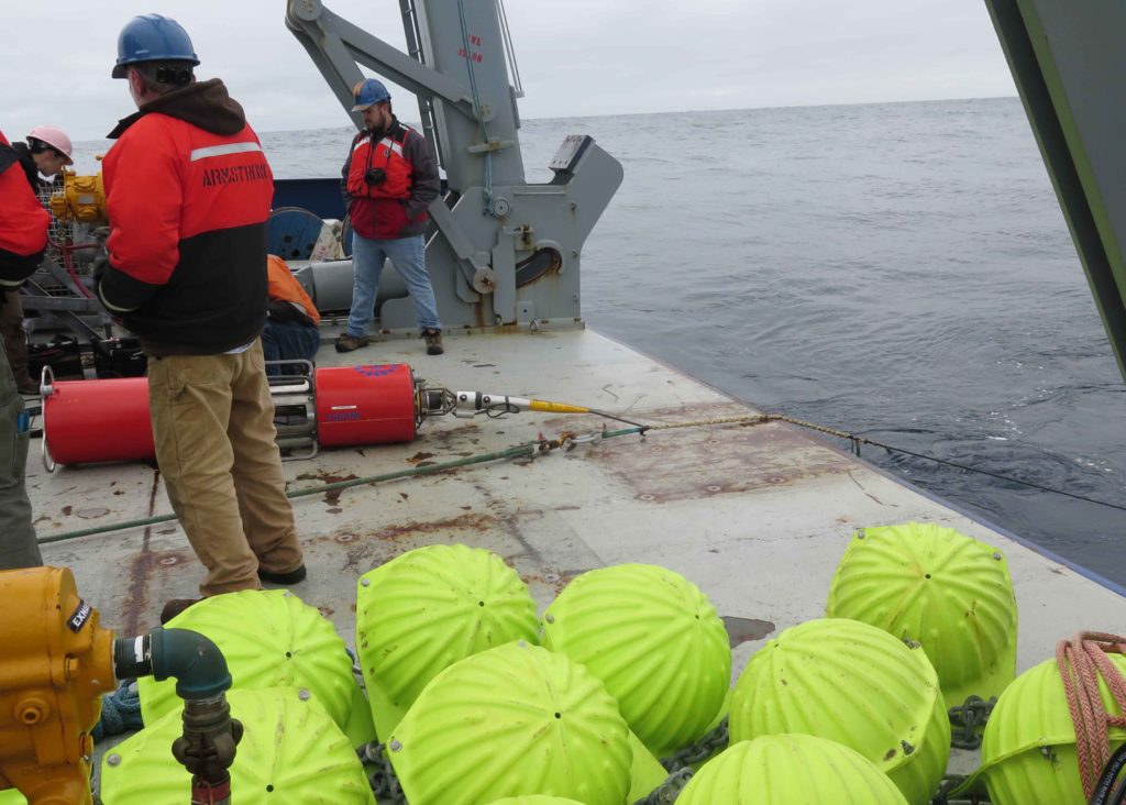 Photo of a large instrument on the back deck of a ship connected to a wire with a YaleGrip woven around the wire.