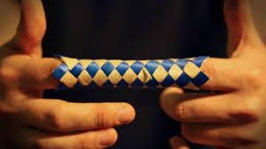 Photo of a finger trap, a woven paper toy.